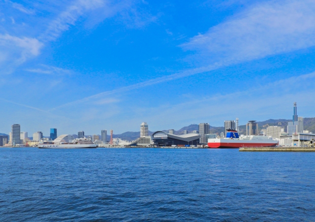 Kobe harbor skyline with ships and GLION ARENA KOBE in the distance across the water