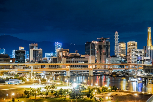Kobe night view with a waterfront park, an elevated roadway, and a lit-up skyline