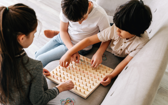 Children playing a board game on a sofa
