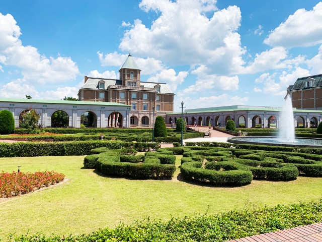 A garden and fountain at Kobe Fruit Flower Park Ozo with manicured greenery and buildings