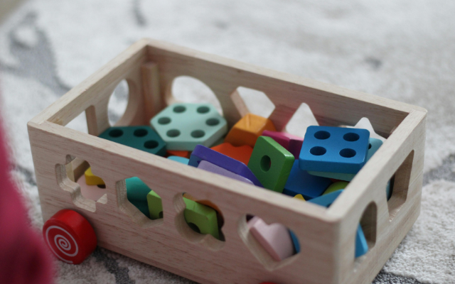 A wooden shape-sorting toy filled with colorful blocks